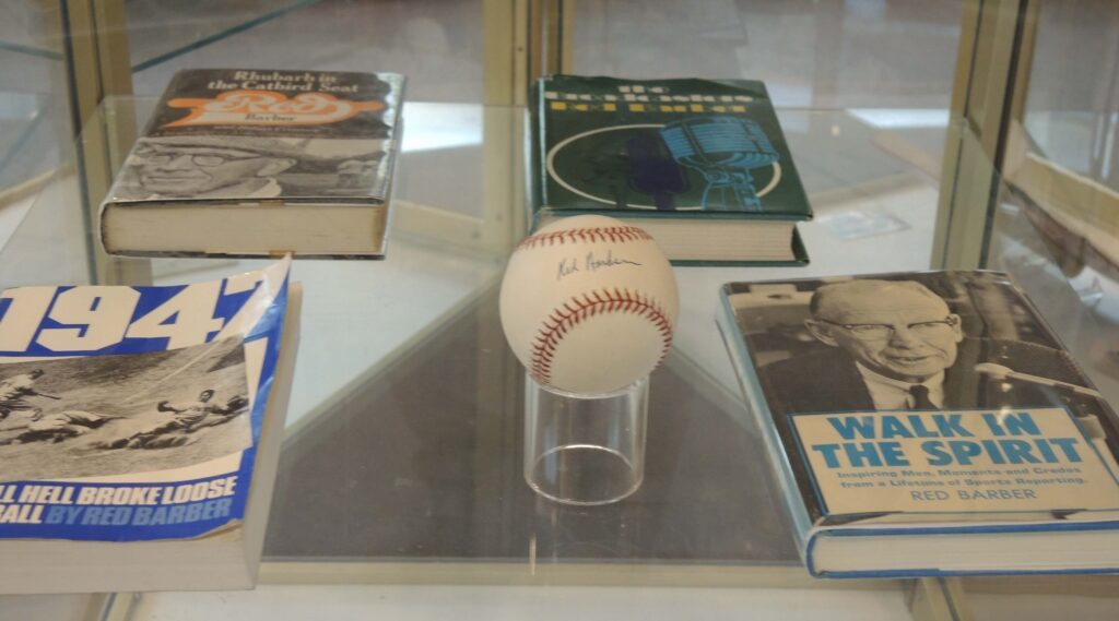 A signed baseball surrounded by books on display