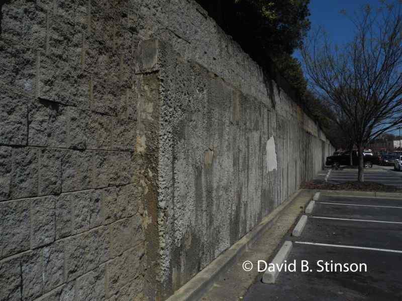 A long cement wall at the parking lot