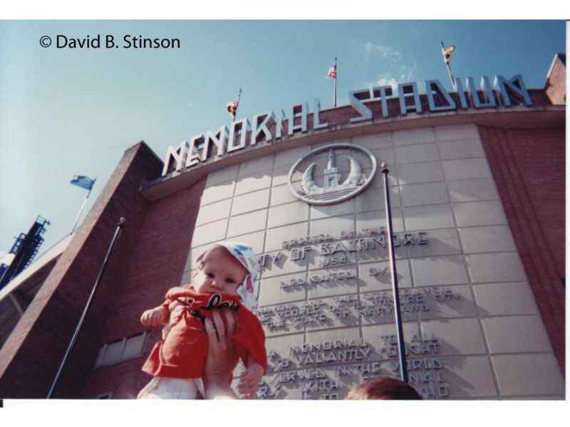 A baby lifted up in front of the stadium entrance